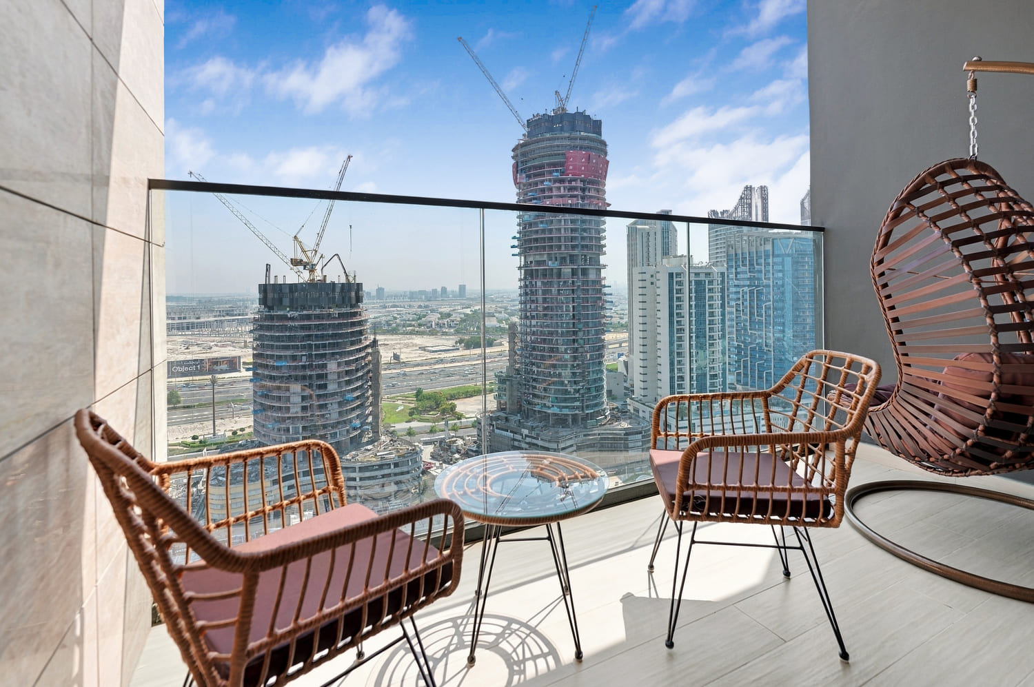 Balcony outdoor lounge furniture framed against the Business Bay skyline and shimmering canal water