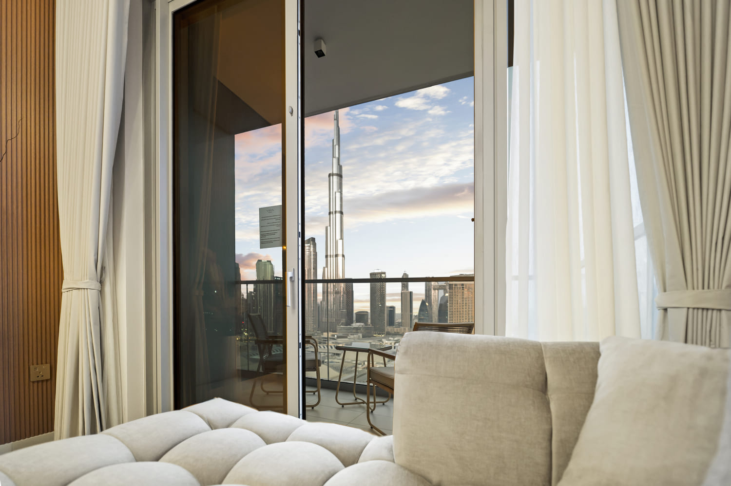 Open-plan dining and living room looking out onto the private balcony and Downtown Dubai skyline at Vida Tower 2
