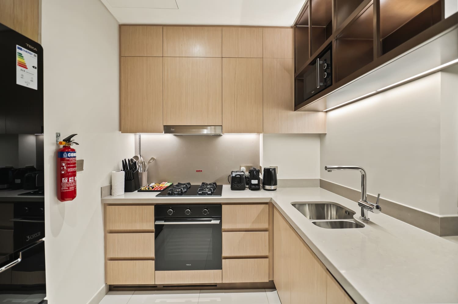 Sleek kitchen cabinetry, quartz countertops, and espresso station in Vida Tower 2 holiday home