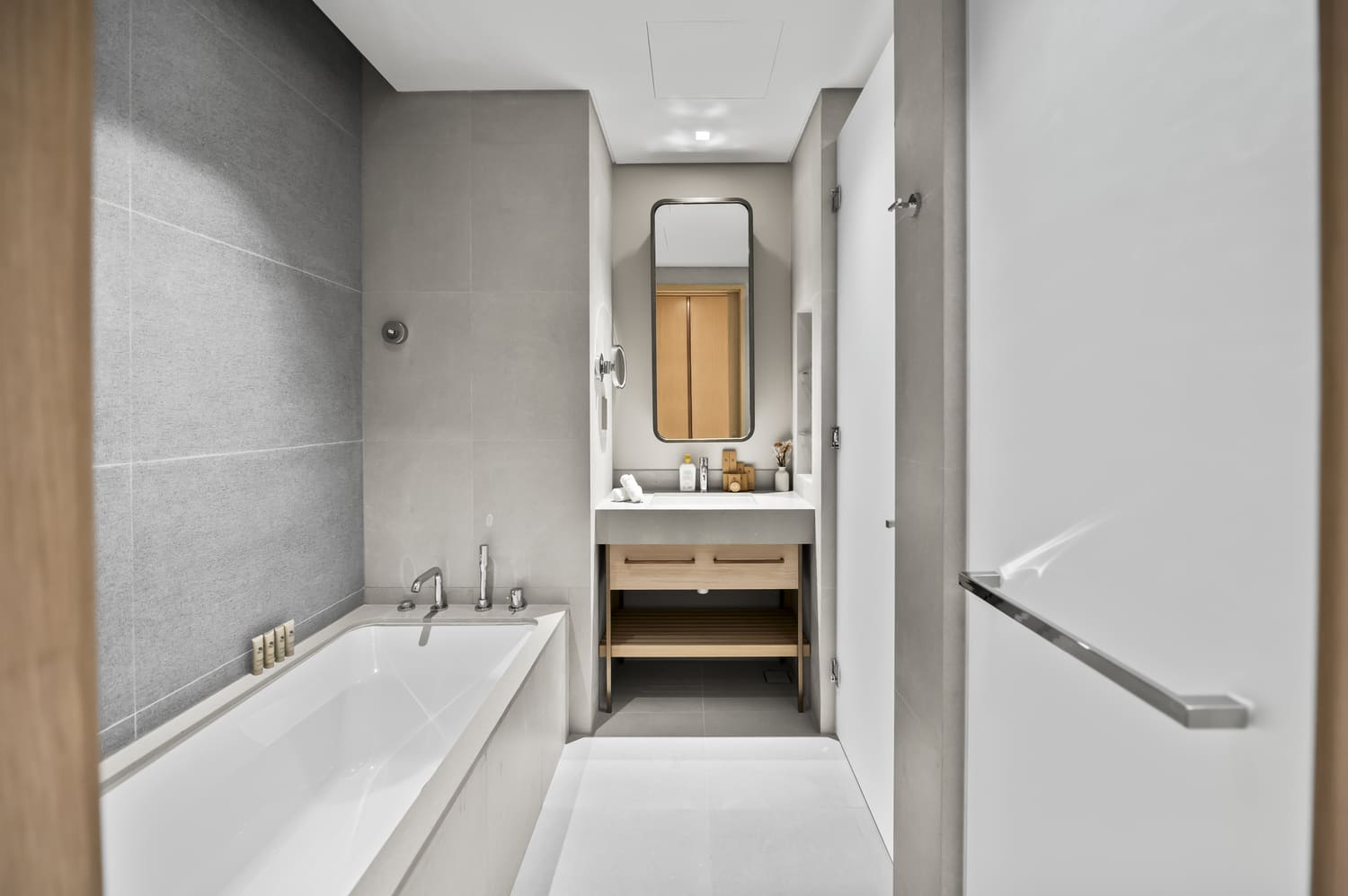 Frameless glass walk-in rain shower and stone tile finishes in Vida Tower 2 Dubai Mall bathroom